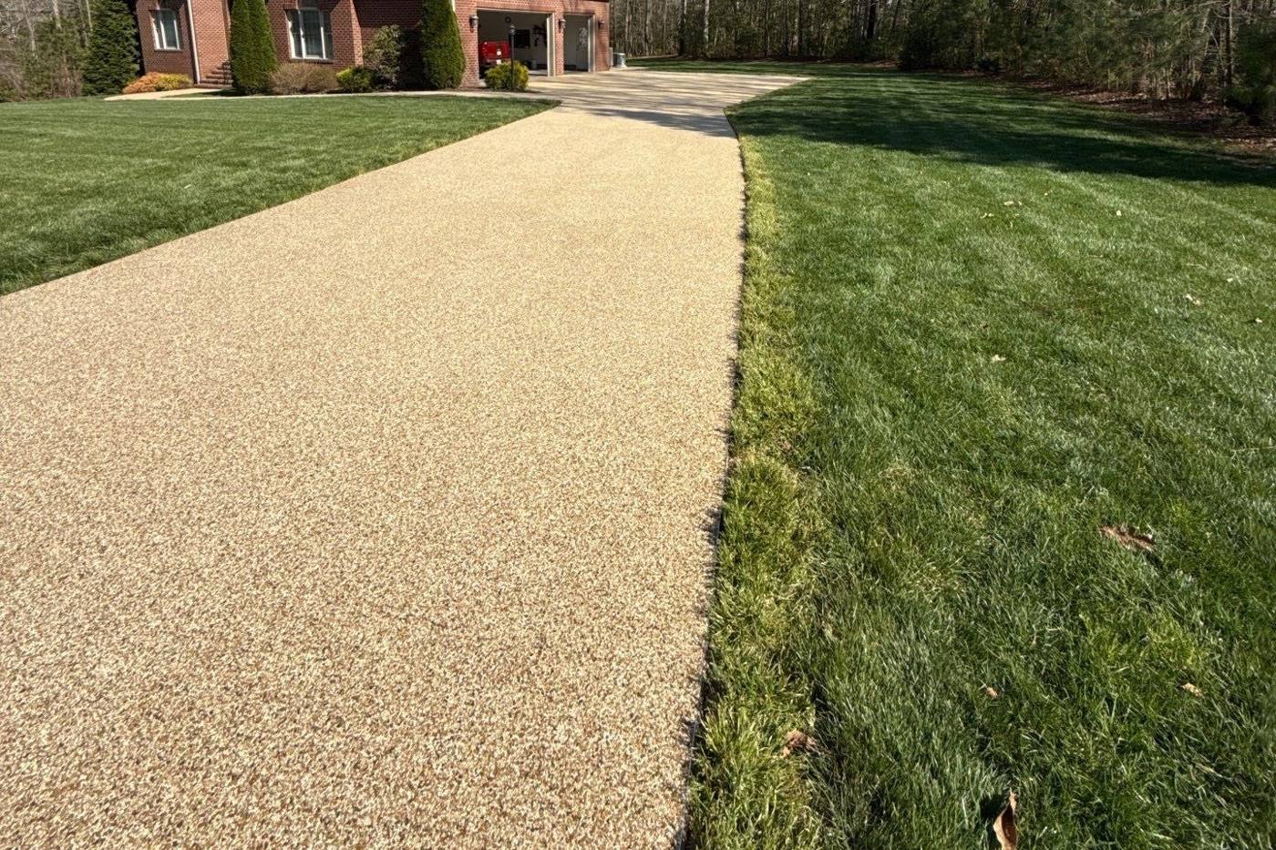 Resin bound driveway in a golden sand blend running up to a brick home